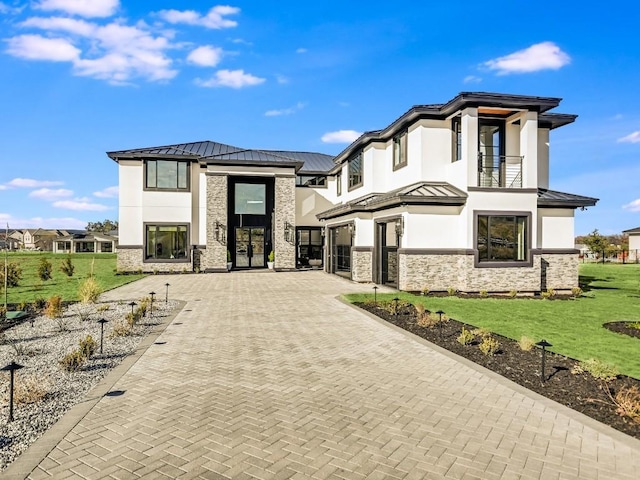 view of front of home featuring a front lawn and a balcony