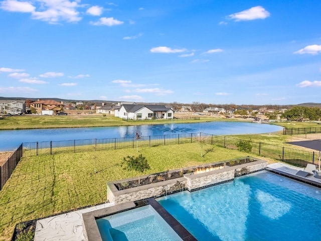 view of pool with a yard and a water view