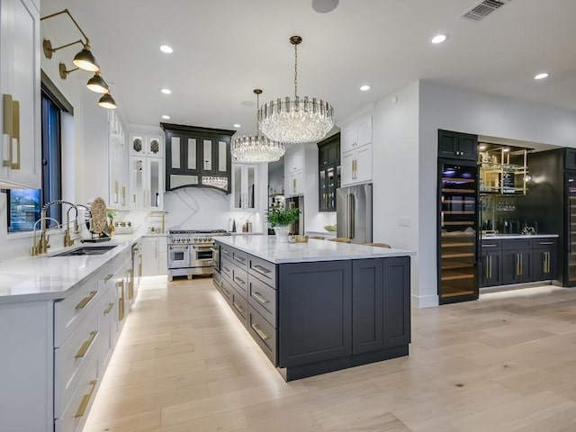 kitchen featuring pendant lighting, high quality appliances, a center island, and white cabinets