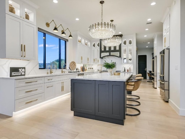 kitchen with white cabinetry, decorative light fixtures, and a kitchen island