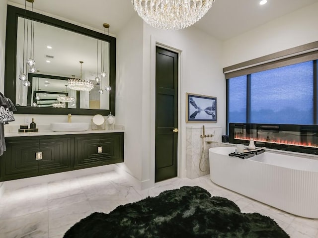 bathroom with vanity, a tub to relax in, and a chandelier