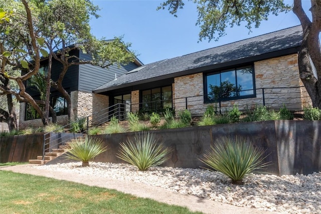 view of front of home featuring stairway and stone siding