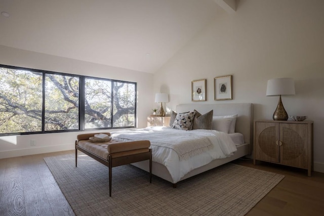 bedroom with wood finished floors, high vaulted ceiling, and baseboards