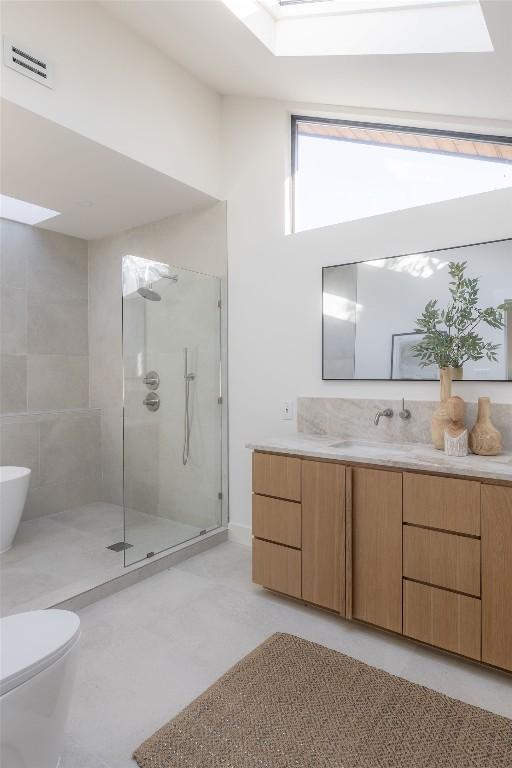 bathroom featuring visible vents, toilet, a shower stall, and vanity