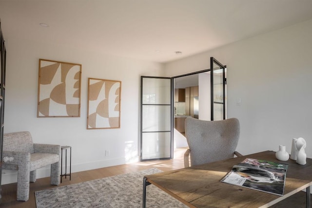 home office with baseboards and wood finished floors