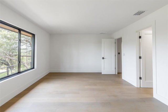 empty room with visible vents, baseboards, and light wood-style flooring