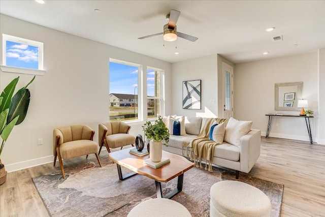 living room featuring light hardwood / wood-style flooring and ceiling fan