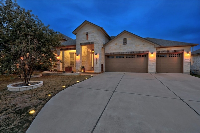 view of front of home with stone siding, concrete driveway, a garage, and a shingled roof