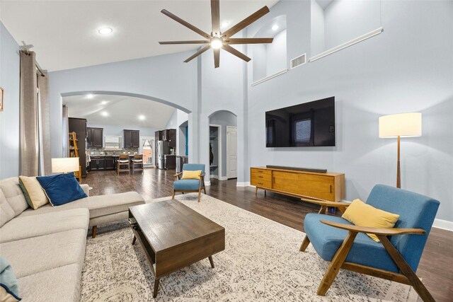 living room featuring visible vents, recessed lighting, arched walkways, ceiling fan, and dark wood-type flooring