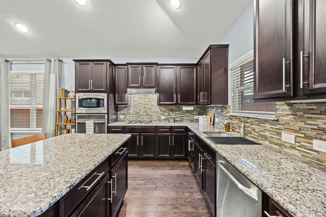 kitchen with a sink, stainless steel appliances, tasteful backsplash, and dark wood-style floors