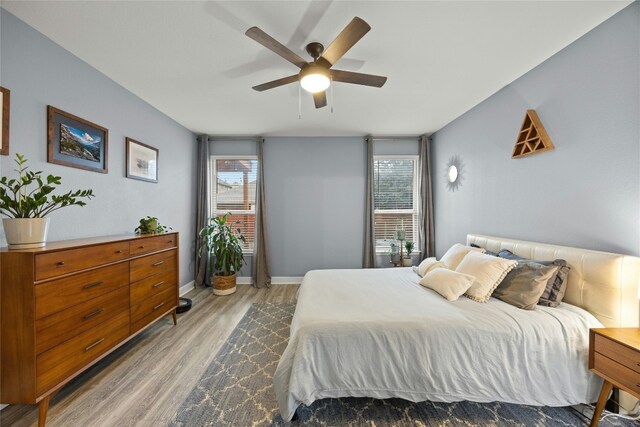 bedroom featuring ceiling fan, baseboards, and wood finished floors