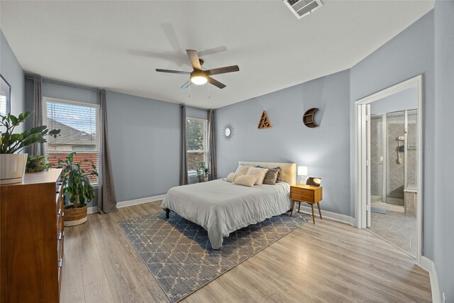 bedroom with visible vents, multiple windows, baseboards, and wood finished floors