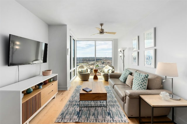 living room featuring ceiling fan, floor to ceiling windows, and light hardwood / wood-style floors