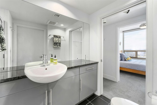 bathroom with tile patterned flooring, vanity, and toilet