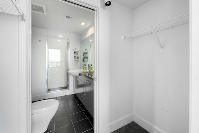 bathroom featuring tile patterned flooring, vanity, and a shower with shower door