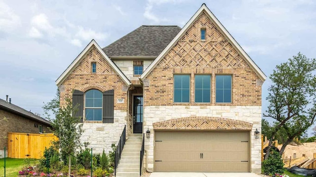 128 Spring Bluff Ln, Georgetown, TX 78628 - tudor-style house with stone siding, a garage, driveway, and brick siding