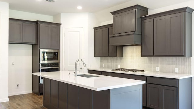 128 Spring Bluff Ln, Georgetown, TX 78628 - kitchen featuring stainless steel appliances, decorative backsplash, dark wood finished floors, an island with sink, and recessed lighting
