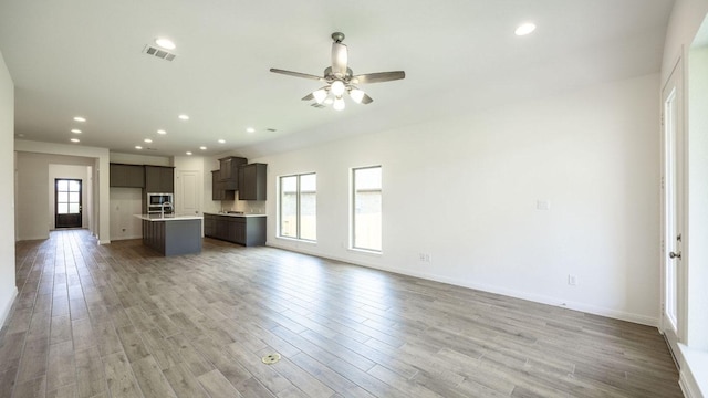 128 Spring Bluff Ln, Georgetown, TX 78628 - unfurnished living room with light wood-type flooring, ceiling fan, and recessed lighting