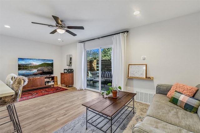 living room with light wood-type flooring, ceiling fan, visible vents, and recessed lighting