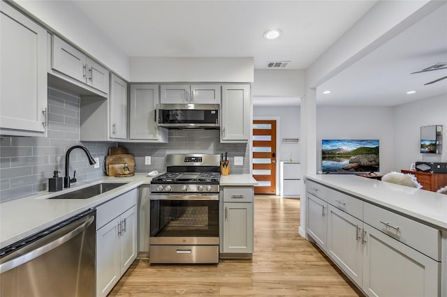 kitchen with light countertops, appliances with stainless steel finishes, a sink, and visible vents