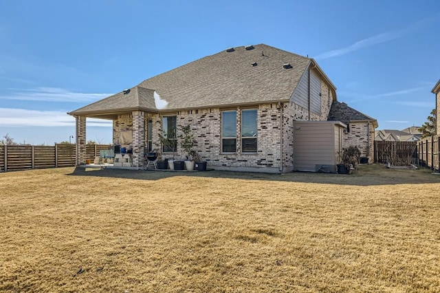 back of house with a patio area and a lawn