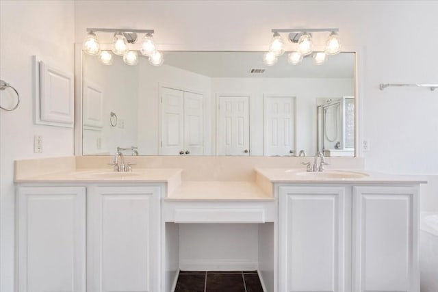 bathroom with an enclosed shower, vanity, and tile patterned floors