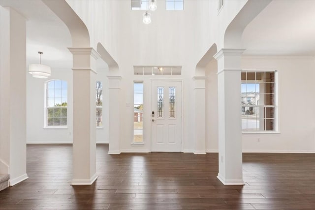 entrance foyer with decorative columns and dark hardwood / wood-style floors