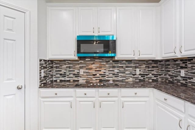 kitchen featuring tasteful backsplash, white cabinets, black electric cooktop, and dark stone counters