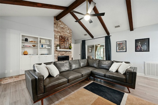 living room with a fireplace, lofted ceiling with beams, ceiling fan, light wood-type flooring, and built in shelves