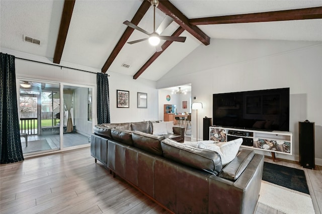 living room featuring high vaulted ceiling, a textured ceiling, beamed ceiling, ceiling fan, and light hardwood / wood-style floors