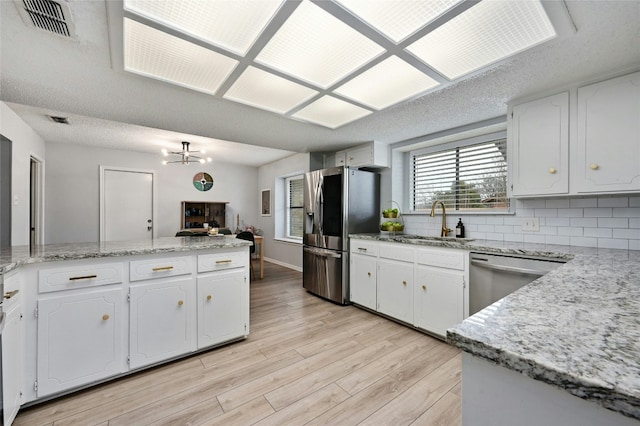 kitchen featuring sink, white cabinetry, tasteful backsplash, kitchen peninsula, and stainless steel appliances