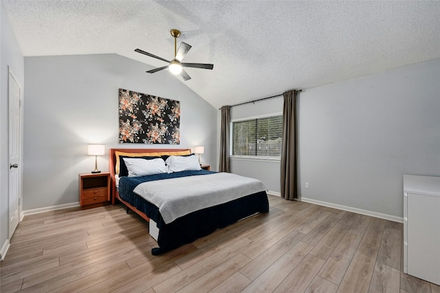 bedroom featuring lofted ceiling, light wood-type flooring, a textured ceiling, and ceiling fan