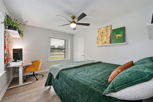 bedroom with ceiling fan, hardwood / wood-style floors, and a textured ceiling