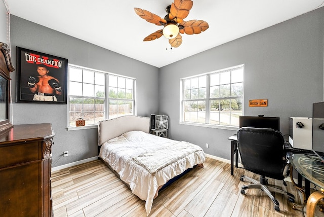 bedroom featuring wood finished floors, a ceiling fan, and baseboards