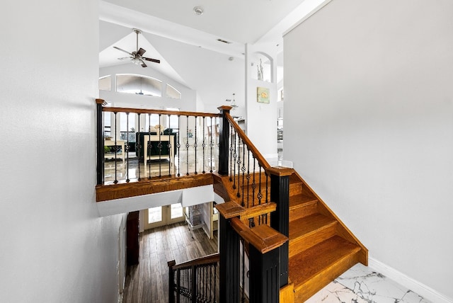 staircase featuring high vaulted ceiling, a ceiling fan, visible vents, baseboards, and marble finish floor