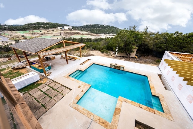 outdoor pool with a patio and a mountain view