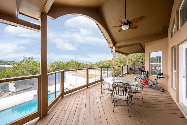 wooden terrace featuring an outdoor pool and a ceiling fan