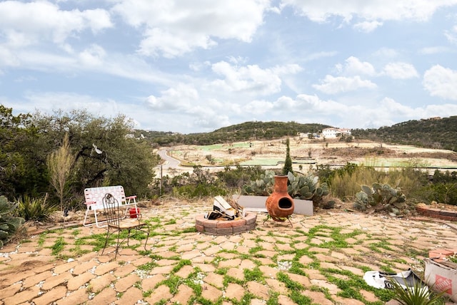 view of yard featuring a patio area, a fire pit, and a mountain view