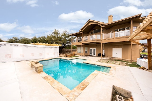 view of swimming pool with french doors, a patio area, fence, and a fenced in pool