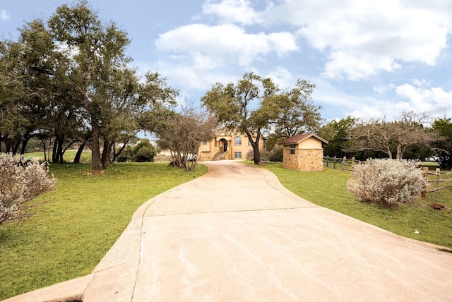 view of front of property with concrete driveway and a front lawn