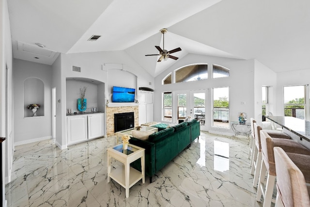 living area featuring a glass covered fireplace, french doors, visible vents, and marble finish floor