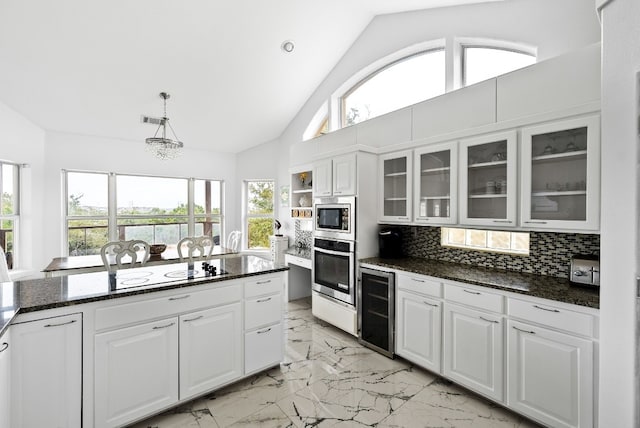 kitchen featuring beverage cooler, white cabinets, appliances with stainless steel finishes, marble finish floor, and backsplash