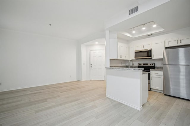 kitchen featuring stainless steel appliances, a raised ceiling, visible vents, and light wood-style floors