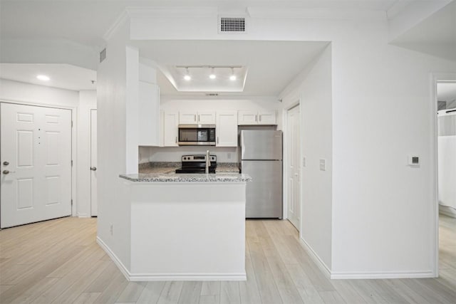 kitchen with light wood finished floors, appliances with stainless steel finishes, white cabinets, and crown molding