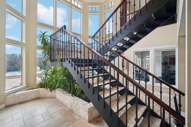 staircase featuring a wealth of natural light and a high ceiling