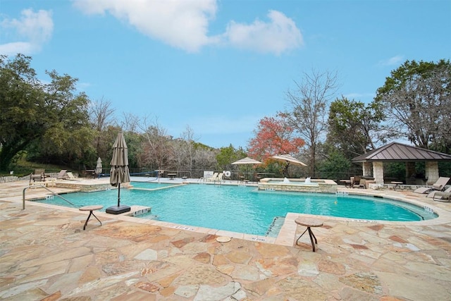 view of pool featuring a hot tub, a gazebo, and a patio area