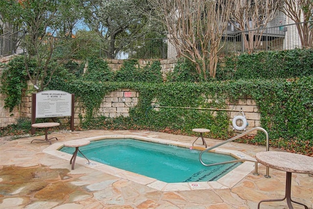 view of swimming pool with a patio area and fence