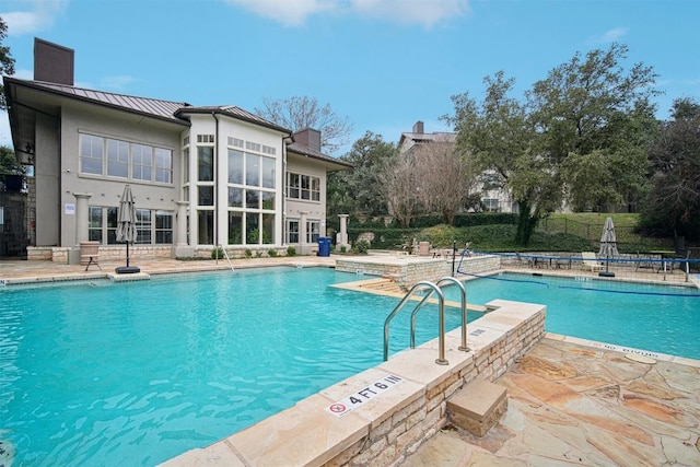 community pool with a patio and fence