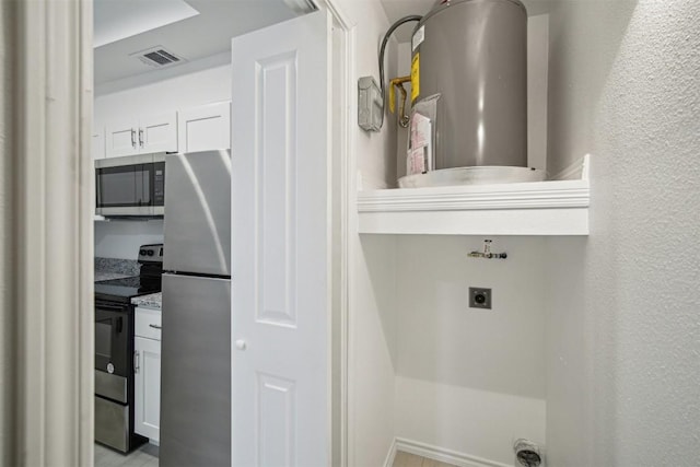 clothes washing area featuring visible vents, a textured wall, electric dryer hookup, and water heater