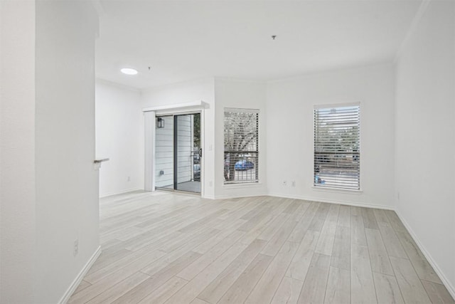 unfurnished room with light wood-style flooring and baseboards